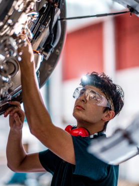 Aircraft mechanic inspecting and checking a jet engine.
